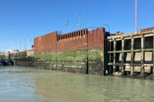 The original turning plate is a large steel structure attached to the quay wall. The bottom half is marked and scuffed from years of contact with the ferries. 