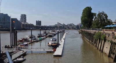 Sunny view from the walkway of the marina of the two pontoon lines with boats moored.